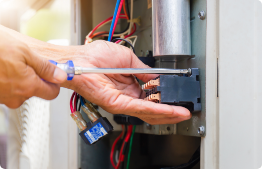 Image of person's hands in wires working on electrical work.