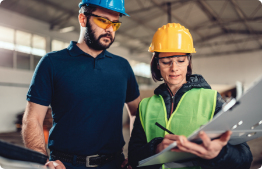 A man and a woman looking at construction plans.